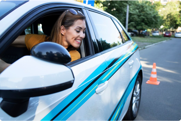 Happy woman learning to reverse car during lesson